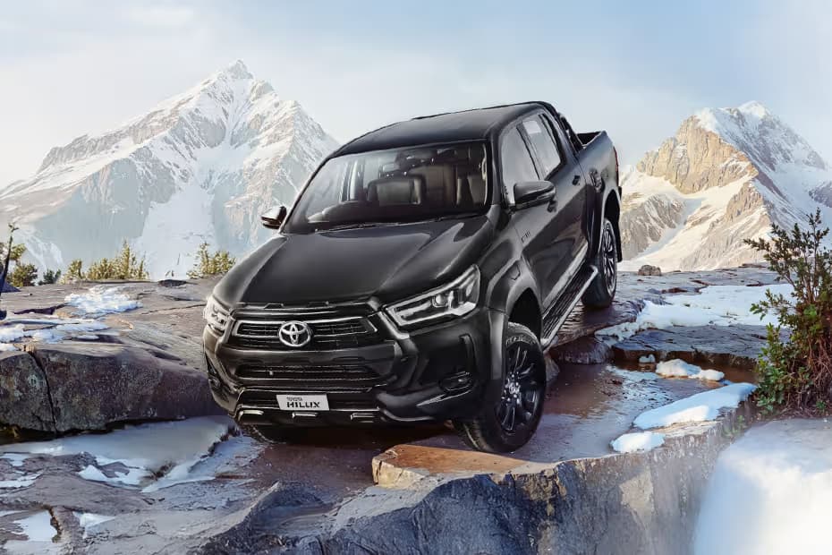 Toyota Hilux STD Truck Diesel car front three-quarter view India 2026 price mileage safety specs side by side car comparison vs Isuzu V-Cross AiCarAdvisor